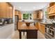 Sunlit kitchen featuring wood cabinets, stainless steel appliances, and an island at 206 Flora Ne Ave, Atlanta, GA 30307