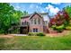Expansive backyard view of this two-story brick home, featuring a deck and patio at 213 Shady Valley Dr, Carrollton, GA 30116