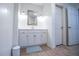 Bright bathroom featuring white cabinets, a framed mirror, and classic tile flooring at 213 Shady Valley Dr, Carrollton, GA 30116