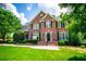 Stately brick home with black shutters and lush green lawn and mature trees at 213 Shady Valley Dr, Carrollton, GA 30116