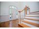 Elegant foyer showcases wood floors, a grand staircase, and a bright entryway with transom windows at 213 Shady Valley Dr, Carrollton, GA 30116