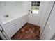 Mud room features tile floor, utility sink, white cabinets, and convenient access to the outdoors at 213 Shady Valley Dr, Carrollton, GA 30116