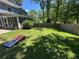 Large, grassy backyard with mature trees, a privacy fence, and a screened porch at 4080 Longford Ne Dr, Marietta, GA 30066