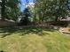 Expansive backyard with lush lawn, mature trees, and a newly installed retaining wall at 4080 Longford Ne Dr, Marietta, GA 30066