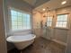 Modern bathroom with a clawfoot tub and a glass-enclosed shower; natural light pours in at 4080 Longford Ne Dr, Marietta, GA 30066