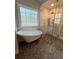 Modern bathroom with a clawfoot tub and a glass-enclosed shower; natural light pours in at 4080 Longford Ne Dr, Marietta, GA 30066