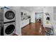 Modern kitchen featuring stainless steel appliances, white cabinetry, hardwood floors, and a laundry area at 4166 Idlevale Dr, Tucker, GA 30084