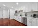 Well-lit kitchen with white cabinetry, stainless steel appliances, gold hardware, and hardwood flooring at 4166 Idlevale Dr, Tucker, GA 30084