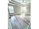 Spacious bedroom with modern flooring, a ceiling fan, and ample natural light from large windows at 6945 Autumn Hills Dr, Cumming, GA 30028
