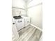 A dedicated laundry room featuring modern washer and dryer on a hardwood floor at 6945 Autumn Hills Dr, Cumming, GA 30028