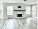 Bright living room featuring a modern fireplace, updated flooring, and ample natural light from large windows at 6945 Autumn Hills Dr, Cumming, GA 30028