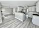 Open-concept living space with updated flooring, stainless steel appliances, and a breakfast bar at 6945 Autumn Hills Dr, Cumming, GA 30028