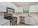 Modern kitchen with white cabinets, stainless steel appliances, updated countertops, and natural light at 2748 Suwanee Se Way, Marietta, GA 30067
