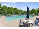 Beautiful community pool with tables, chairs, and umbrellas surrounded by lush trees on a sunny day at 3524 Old Towne Ln, Cumming, GA 30040