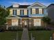 Charming two-story home with a stone and blue-painted wood facade, complemented by a well-manicured lawn at 3524 Old Towne Ln, Cumming, GA 30040
