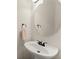 Elegant powder room featuring a pedestal sink, round mirror, and stylish bronze fixtures at 3524 Old Towne Ln, Cumming, GA 30040