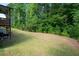 A well-maintained backyard featuring a large, lush lawn and surrounding forest at 63 Brookstone E Park, Acworth, GA 30101