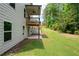 Two-story home exterior featuring a covered porch overlooking a well-manicured backyard at 63 Brookstone E Park, Acworth, GA 30101