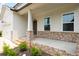 Inviting front porch with stone accents and manicured landscaping, adjacent to a two-car garage at 63 Brookstone E Park, Acworth, GA 30101