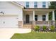 Inviting front porch with stone accents and manicured landscaping, adjacent to a two-car garage at 63 Brookstone E Park, Acworth, GA 30101