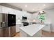 Bright, open kitchen featuring white cabinets, stainless appliances, and an island with Quartz countertops at 63 Brookstone E Park, Acworth, GA 30101