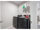 This well-lit laundry room features a black washer and dryer and a wire rack for storage at 63 Brookstone E Park, Acworth, GA 30101
