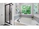Relax in this bathroom's tub with a shower and a view, and black-framed glass shower at 63 Brookstone E Park, Acworth, GA 30101