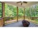 Covered porch with wood railing featuring wooded views and a fire pit at 63 Brookstone E Park, Acworth, GA 30101
