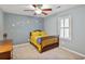 Comfortable bedroom featuring blue walls, ceiling fan, window, and a wooden bed at 1491 Kolb Ridge Sw Dr, Marietta, GA 30008