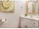 Stylish powder room featuring a white vanity, framed mirror, and modern art at 1491 Kolb Ridge Sw Dr, Marietta, GA 30008