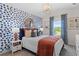 Charming bedroom with a blue patterned wallpaper, a comfortable bed, and a bright window view at 211 Linford Dr, Locust Grove, GA 30248