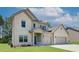 Attractive two-story home featuring light brick, a covered porch, two-car garage, and well-maintained front yard at 211 Linford Dr, Locust Grove, GA 30248