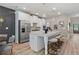 Modern kitchen featuring stainless steel appliances, white cabinets, a large island with seating, and elegant pendant lighting at 211 Linford Dr, Locust Grove, GA 30248