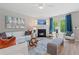 Cozy living room features a fireplace, bright windows with blue curtains, white sofas with colorful pillows, and modern decor at 211 Linford Dr, Locust Grove, GA 30248