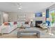Inviting living room with fireplace, white sofa, large windows with vibrant blue curtains, and a modern coastal aesthetic at 211 Linford Dr, Locust Grove, GA 30248