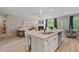 Bright, open-concept living space with a fireplace, large windows, and access to the outdoors; adjacent to an island kitchen at 211 Linford Dr, Locust Grove, GA 30248