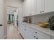 Convenient butler's pantry with white cabinetry, quartz countertops, and a view into the adjacent dining area at 211 Linford Dr, Locust Grove, GA 30248