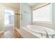 Bathroom features a large soaking tub, glass door shower, and wood-look tile floors at 2333 Orion Ct, Grayson, GA 30017