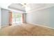 Large bedroom with a tray ceiling, a ceiling fan, and a view of the backyard at 2333 Orion Ct, Grayson, GA 30017