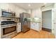 Spacious kitchen with stainless steel appliances, stone countertops, and light wood flooring at 2333 Orion Ct, Grayson, GA 30017