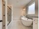 Sleek bathroom featuring a soaking tub, a glass-enclosed shower, and elegant tile flooring at 234 Linford Dr, Locust Grove, GA 30248