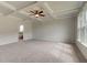 Bright, carpeted main bedroom with decorative ceiling, fan and many windows, attached bath with standalone tub at 234 Linford Dr, Locust Grove, GA 30248