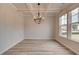 A modern dining room with decorative ceiling, chandelier, and large windows offering natural light at 234 Linford Dr, Locust Grove, GA 30248