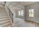 Elegant foyer with wood-look floors, a staircase, and coffered ceilings in the adjacent room at 234 Linford Dr, Locust Grove, GA 30248