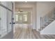 Bright entryway featuring wood-look flooring, a staircase, and an open view to the living area at 234 Linford Dr, Locust Grove, GA 30248