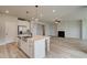 View of the open kitchen and living area featuring an island with seating and a cozy fireplace at 234 Linford Dr, Locust Grove, GA 30248