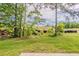 Backyard view featuring a grassed area, mature trees, and a serene natural setting with a partial view of the structure at 5567 Union Pointe Pl, Union City, GA 30291