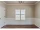 Elegant dining room showcasing wainscoting, hardwood floors, and a large window for natural light at 5567 Union Pointe Pl, Union City, GA 30291