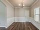 Well-lit dining room with wainscoting, hardwood floors, and chandelier, ready for entertaining at 5567 Union Pointe Pl, Union City, GA 30291