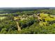 Distant aerial view of home nestled within a vibrant, green, heavily wooded area showing vast acreage at 104 Meadow View Trl, Canton, GA 30115